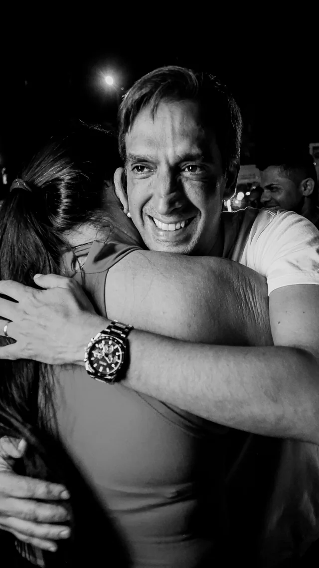 Fotografia em preto e branco de Fábio durante um abraço.