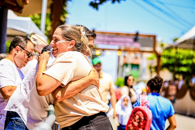 Fábio abraçando uma mulher na rua, durante o dia.